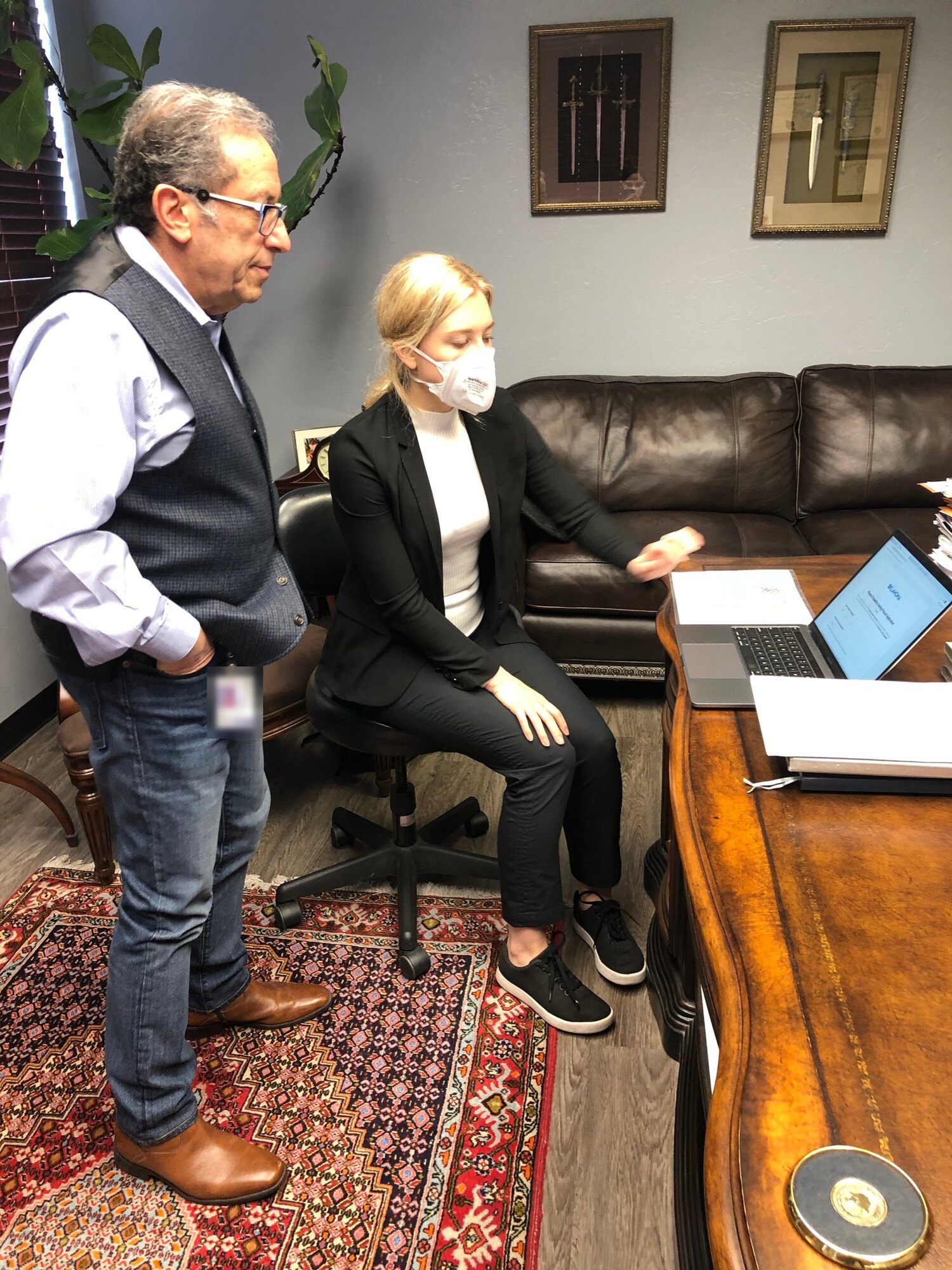 A doctor being walked through the new online disability placard application on a laptop in his office.